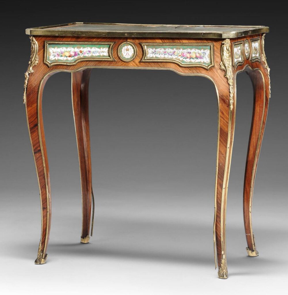 A small early Victorian kingwood and tulipwood banded, porcelain and gilt-bronze mounted writing table by Edward Holmes Baldock.
