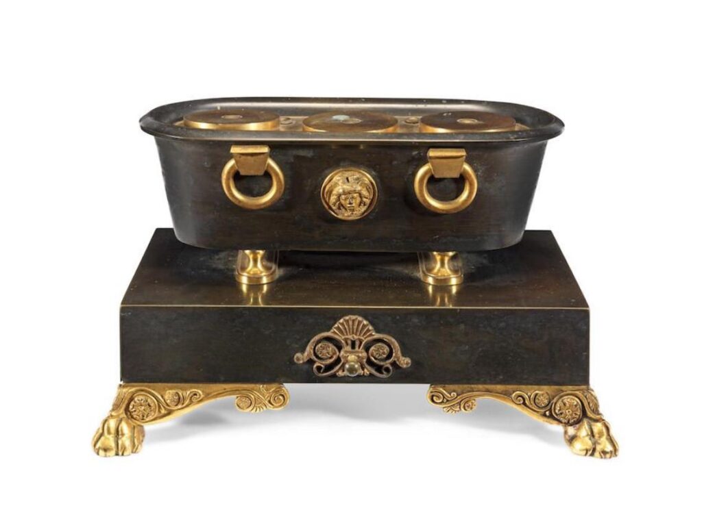 An Empire patinated and gilt bronze encrier, circa 1812.