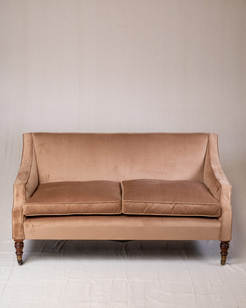 A small sofa in caramel velvet.