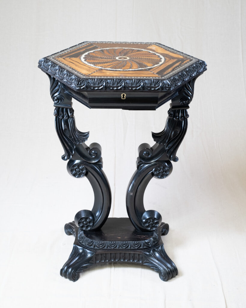 A Ceylonese ebonised hexagonal table with an inlaid top.