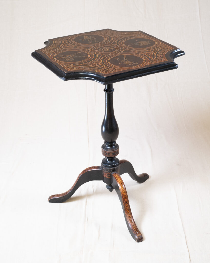 A tripod table with a penwork top.