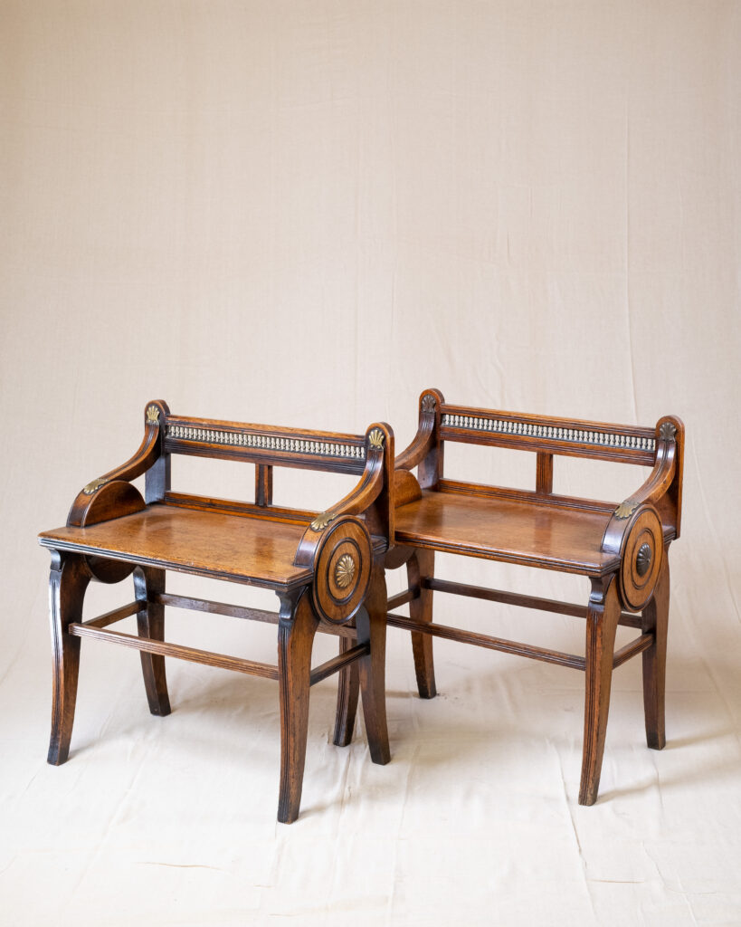 A pair of late 19th century oak hall benches by James Shoolbred &amp; Co .