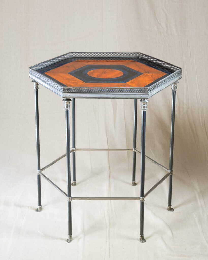 An hexagonal steel and brass table, faux pietra dura top, by Maison Charles, circa 1990.